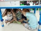 孩子們抱頭保護躲在桌子下